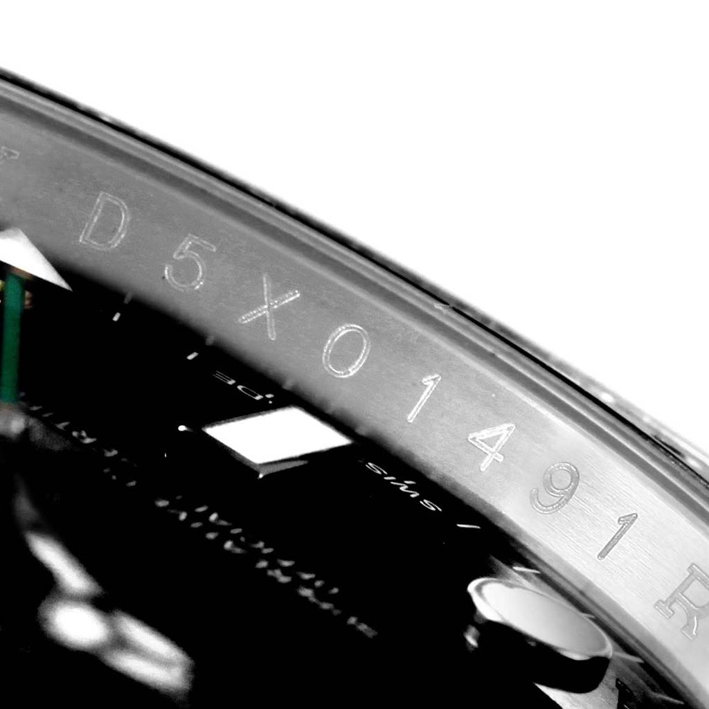 The image shows a close-up of the engraving for the serial number on the inner bezel of a Rolex GMT-Master 116710 Men's Stainless Steel Black Dial 116710 Men's Stainless Steel Black Dial watch.