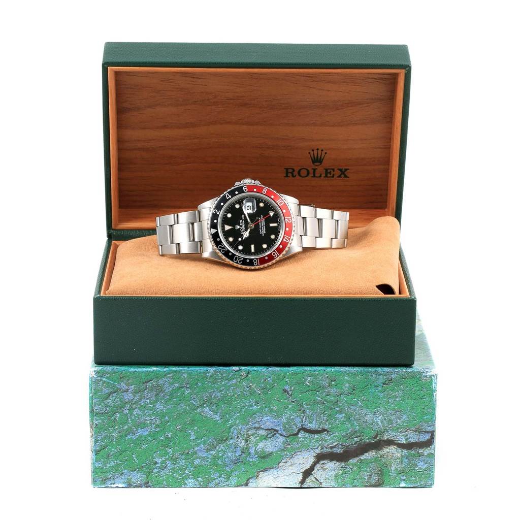 The image shows a Rolex GMT-Master 16700 Men's Stainless Steel Black Dial 16700 Men's Stainless Steel Black Dial watch in its original packaging, with a full view of the watch face and strap.