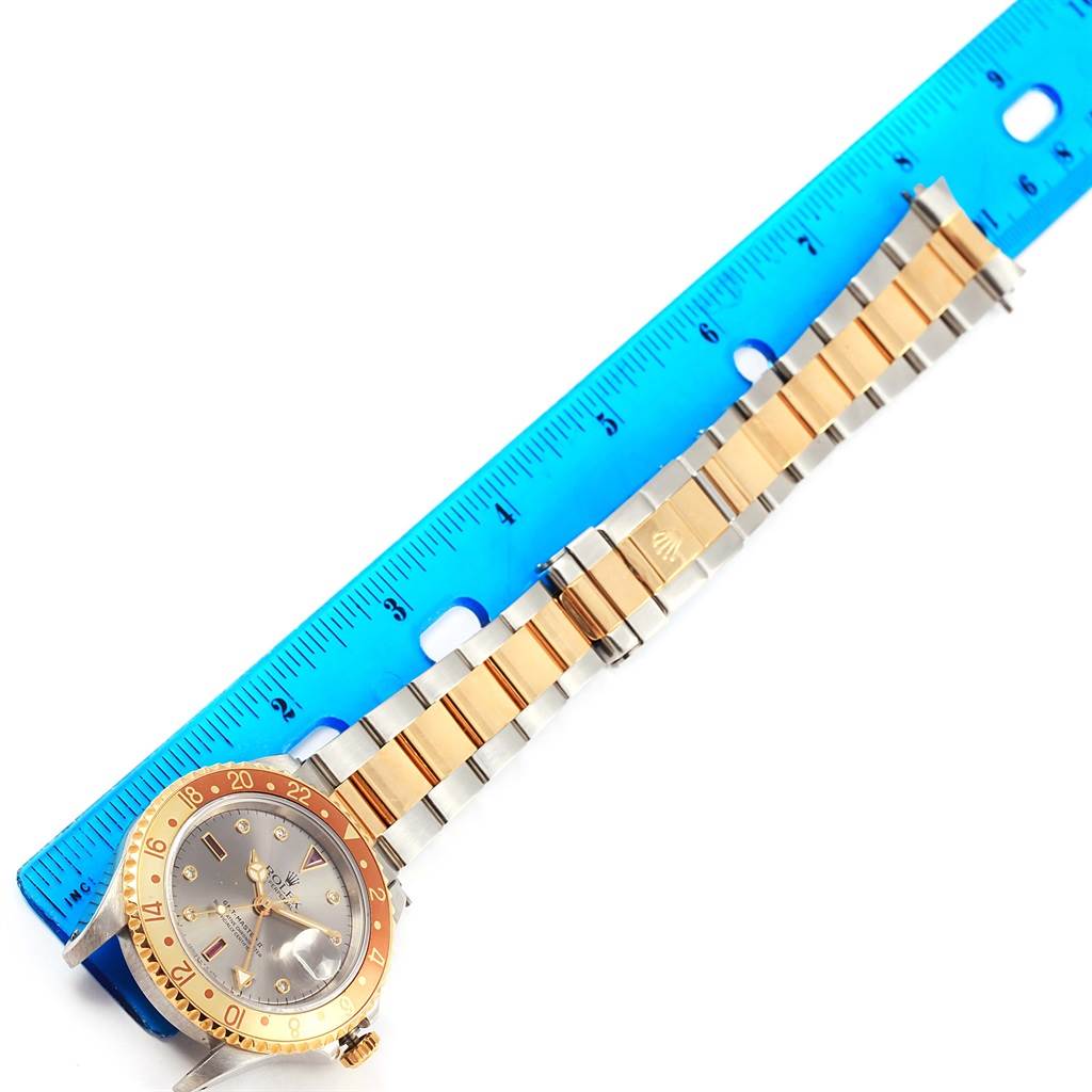 The image shows a Rolex GMT-Master 16713 Men's Stainless Steel Grey Dial 16713 Men's Stainless Steel Grey Dial watch with its bracelet fully extended next to a blue ruler for measurement.