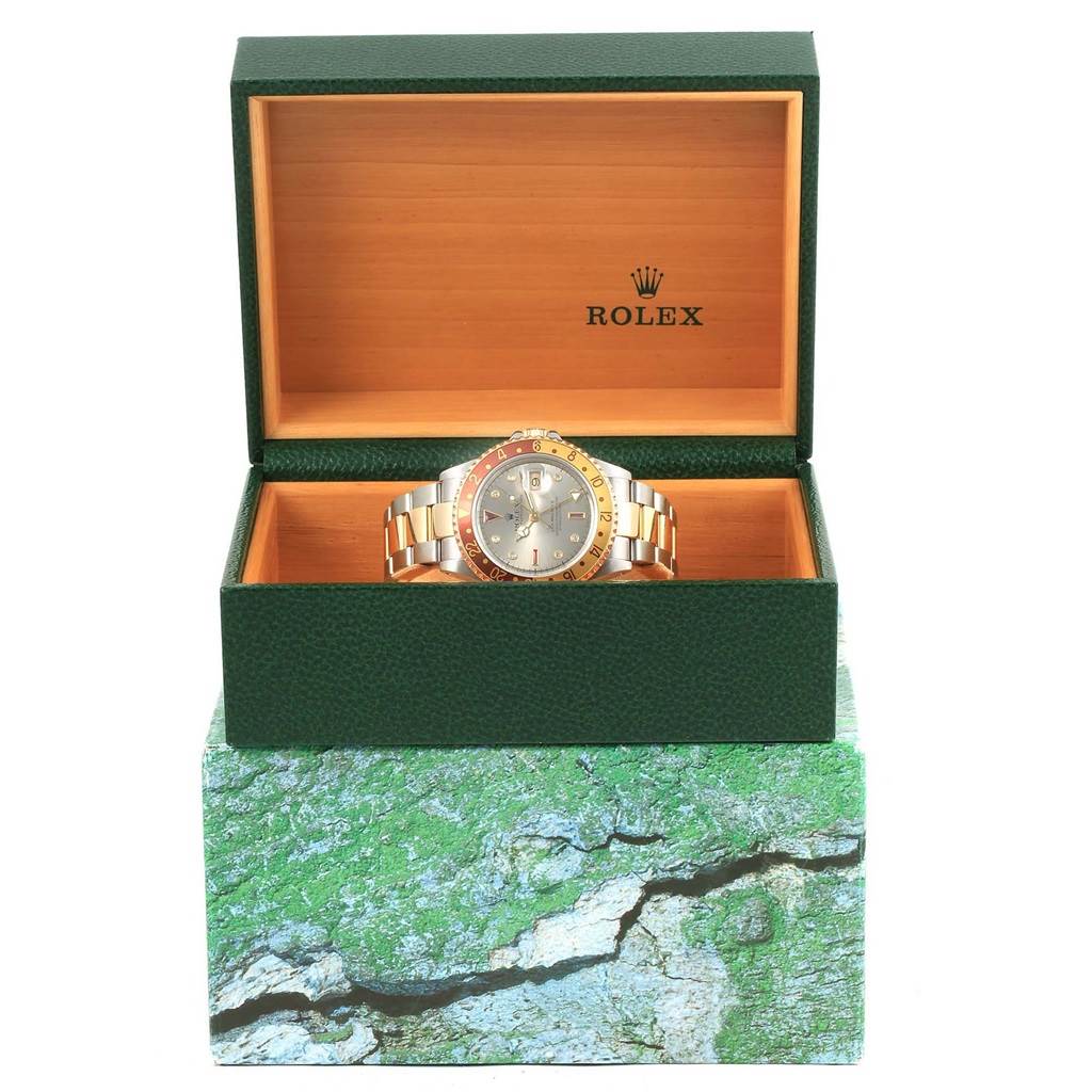 The image shows a Rolex GMT-Master 16713 Men's Stainless Steel Grey Dial 16713 Men's Stainless Steel Grey Dial watch in an open green and wooden Rolex box, placed on a textured green box.