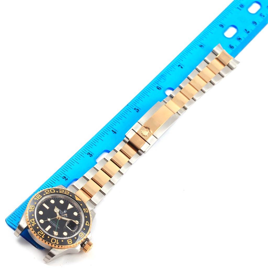 The image shows a Rolex GMT-Master 116713 Men's Stainless Steel Black Dial 116713 Men's Stainless Steel Black Dial watch with its face, bezel, and part of the strap measured against a blue ruler.