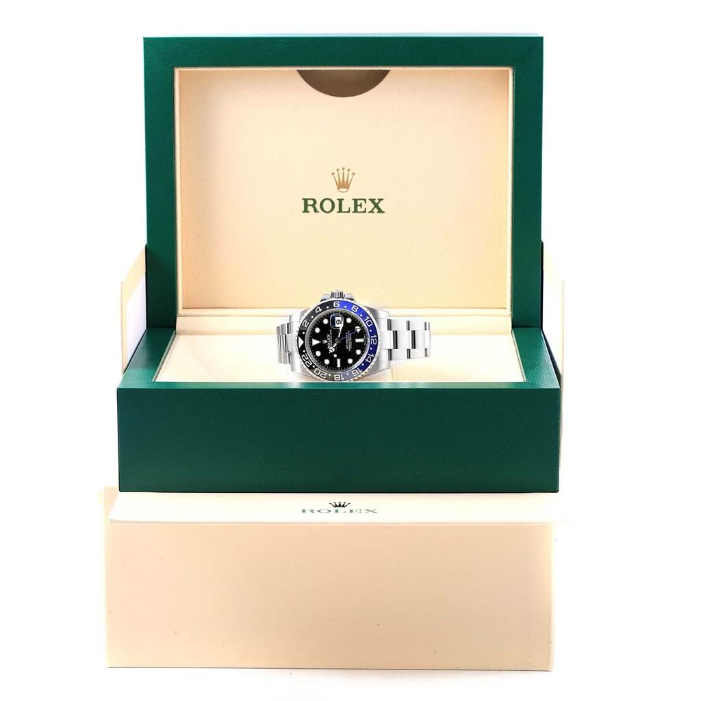 The Rolex GMT-Master 116710 Men's Stainless Steel Black Dial 116710 Men's Stainless Steel Black Dial watch is photographed head-on in its open green and beige branded case.