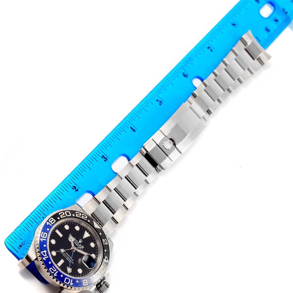The image shows a Rolex GMT-Master 116710 Men's Stainless Steel Black Dial 116710 Men's Stainless Steel Black Dial watch laid flat with the bracelet extended next to a blue ruler for measurement.