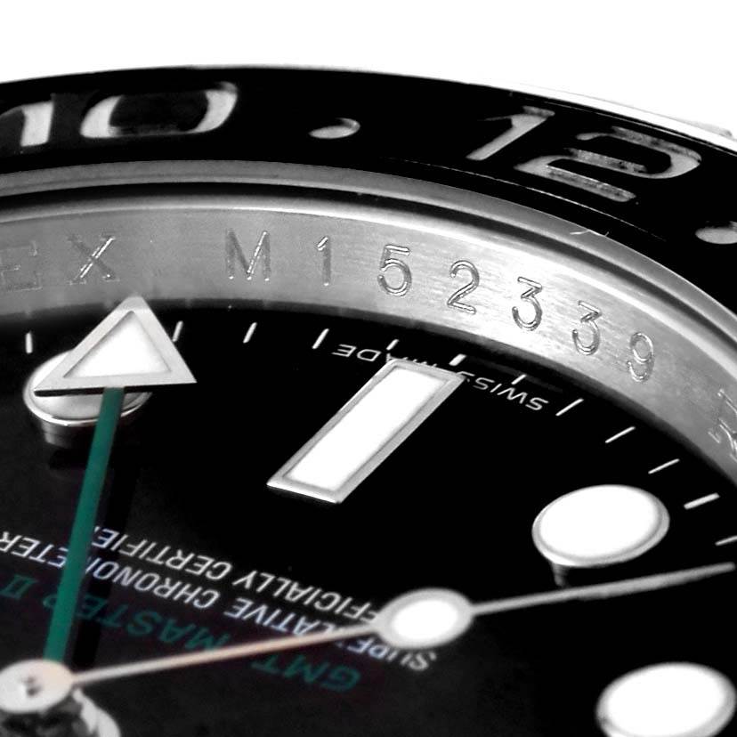 Close-up of the Rolex GMT-Master 116710 Men's Stainless Steel Black Dial 116710 Men's Stainless Steel Black Dial watch, showing part of the bezel, dial, and "ROLEX" engraving along with the serial number.