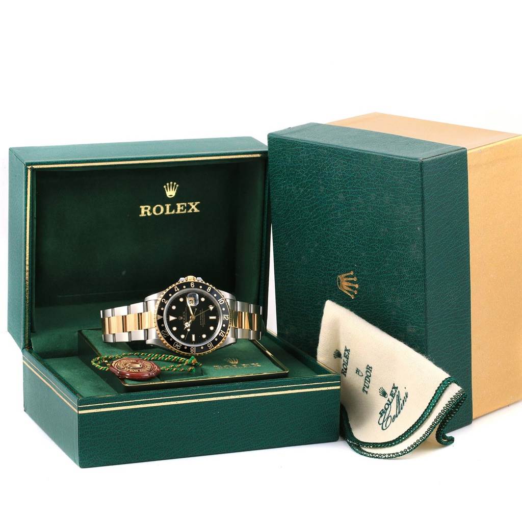 The Rolex GMT-Master 16713 Men
s Stainless Steel Black Dial 16713 Men
s Stainless Steel Black Dial watch is displayed front-on in an open green box, accompanied by a cloth and additional packaging.