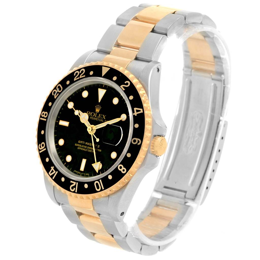 The image shows a Rolex GMT-Master 16713 Men
s Stainless Steel Black Dial 16713 Men
s Stainless Steel Black Dial watch from a three-quarter angle, highlighting its gold and stainless steel bracelet and black bezel.