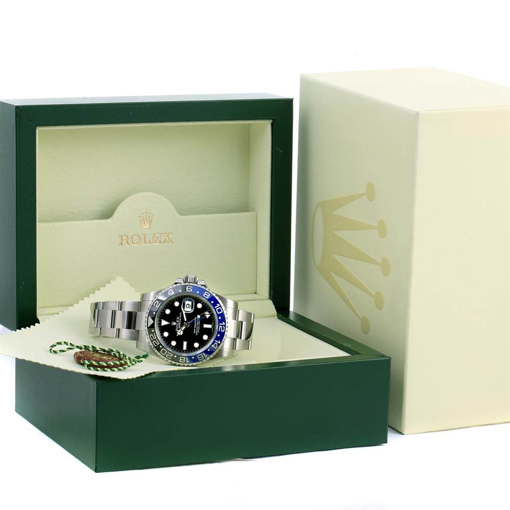 The Rolex GMT-Master 116710 Men's Stainless Steel Black Dial 116710 Men's Stainless Steel Black Dial watch is shown at a front angle, placed in an open green and cream Rolex box with a cleaning cloth and tag.