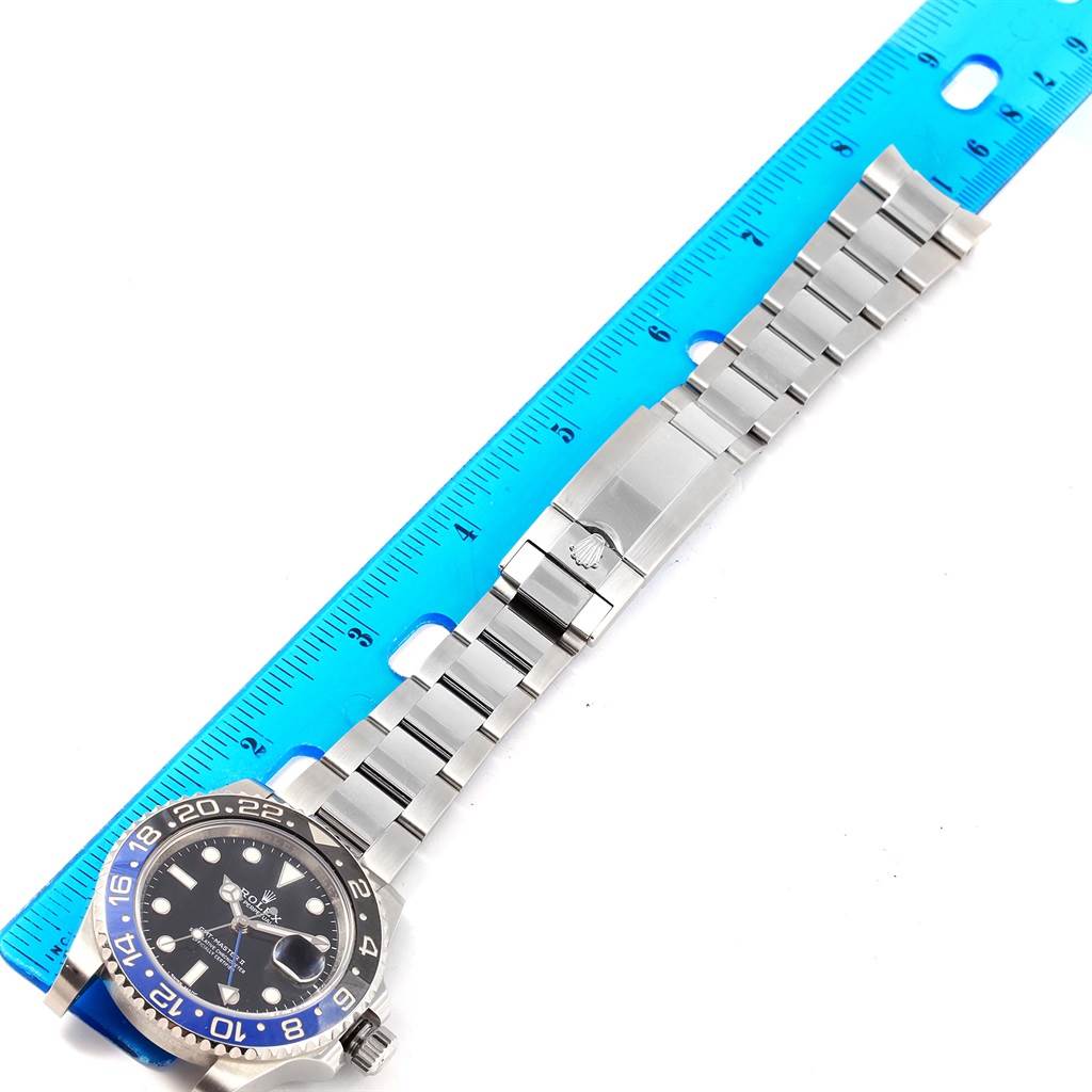 This image shows a Rolex GMT-Master 116710 Men's Stainless Steel Black Dial 116710 Men's Stainless Steel Black Dial watch laid flat with a blue ruler parallel to its bracelet for measurement.