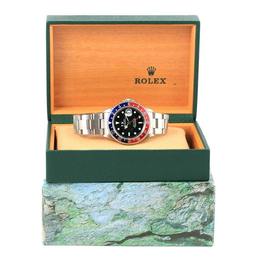 The Rolex GMT-Master 16700 Men's Stainless Steel Black Dial 16700 Men's Stainless Steel Black Dial watch is displayed front-on in an open box, showcasing its bracelet and bezel.