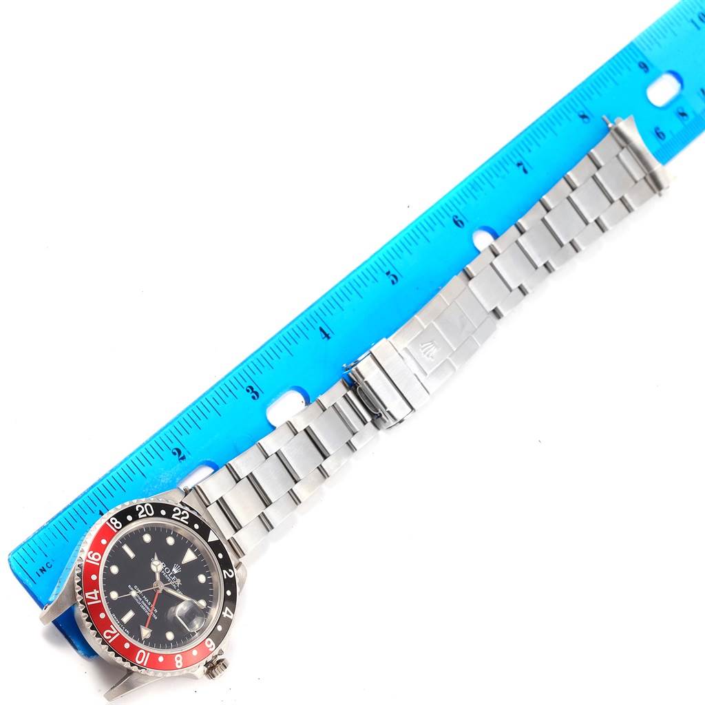 The image shows a Rolex GMT-Master 16700 Men's Stainless Steel Black Dial 16700 Men's Stainless Steel Black Dial watch laid flat next to a blue ruler, highlighting the watch bezel, face, and metal bracelet.