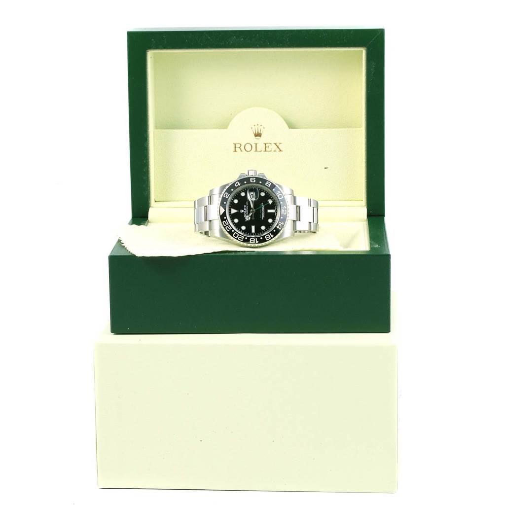 The Rolex GMT-Master 116710 Men's Stainless Steel Black Dial 116710 Men's Stainless Steel Black Dial watch is displayed front-on in its open green and cream-colored branded box.