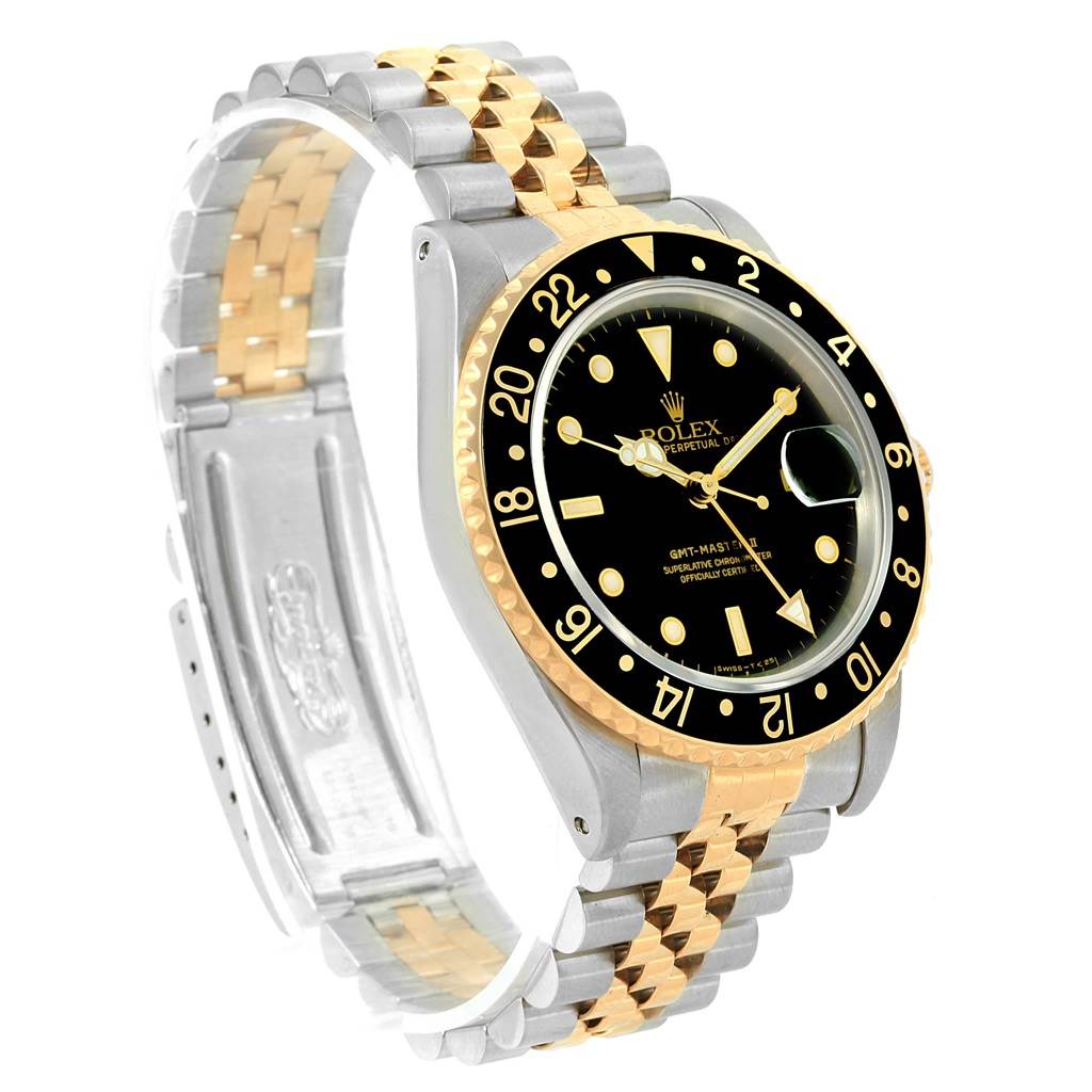 The Rolex GMT-Master 16713 Men's Stainless Steel Silver Dial 16713 Men's Stainless Steel Silver Dial watch is shown at an angle displaying the black dial, gold bezel, and two-tone bracelet.