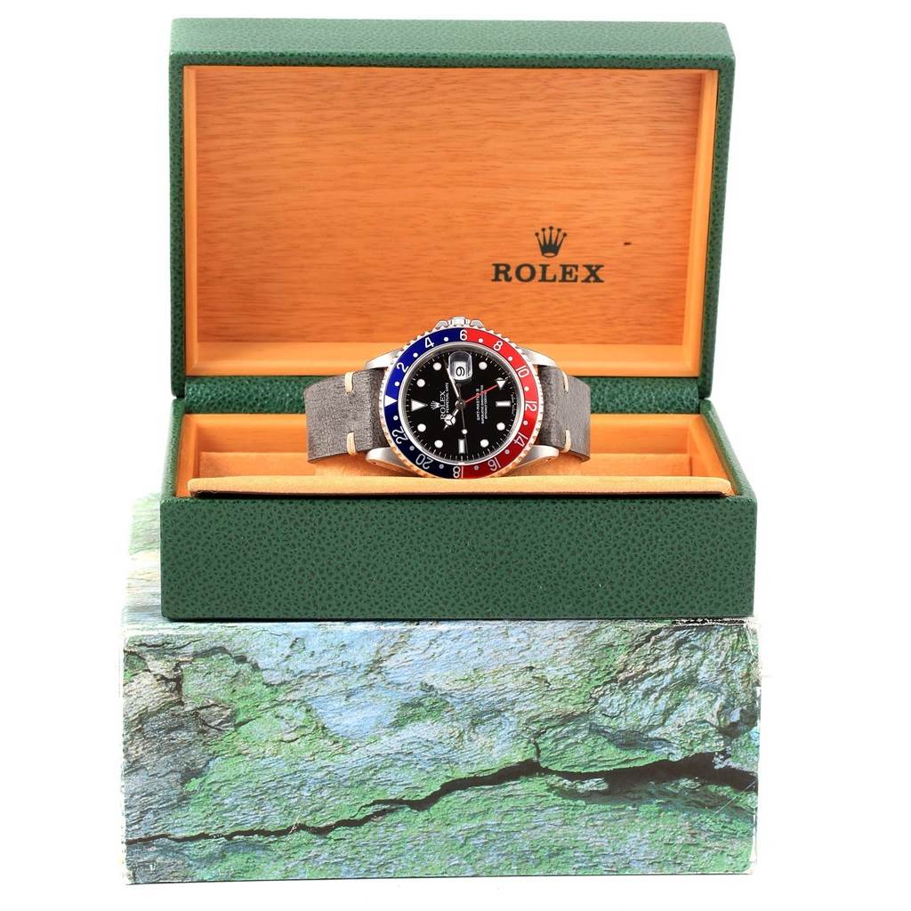 The Rolex GMT-Master 16710 Men's Stainless Steel Black Dial 16710 Men's Stainless Steel Black Dial watch is displayed in its open box, showing the face, bezel, and strap.