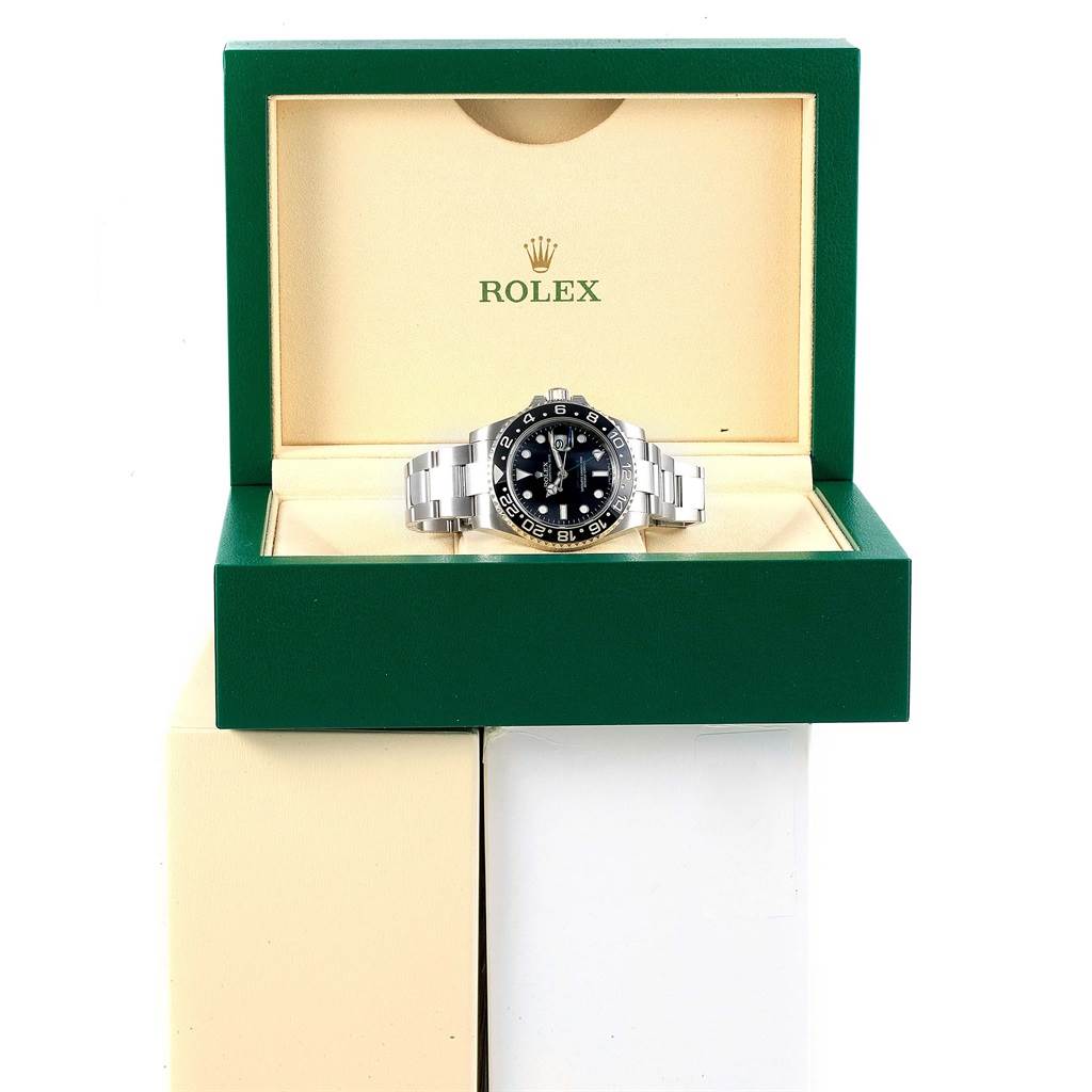 The Rolex GMT-Master 116710 Men
s Stainless Steel Black Dial 116710 Men
s Stainless Steel Black Dial watch is displayed front-facing in a green and beige Rolex box.