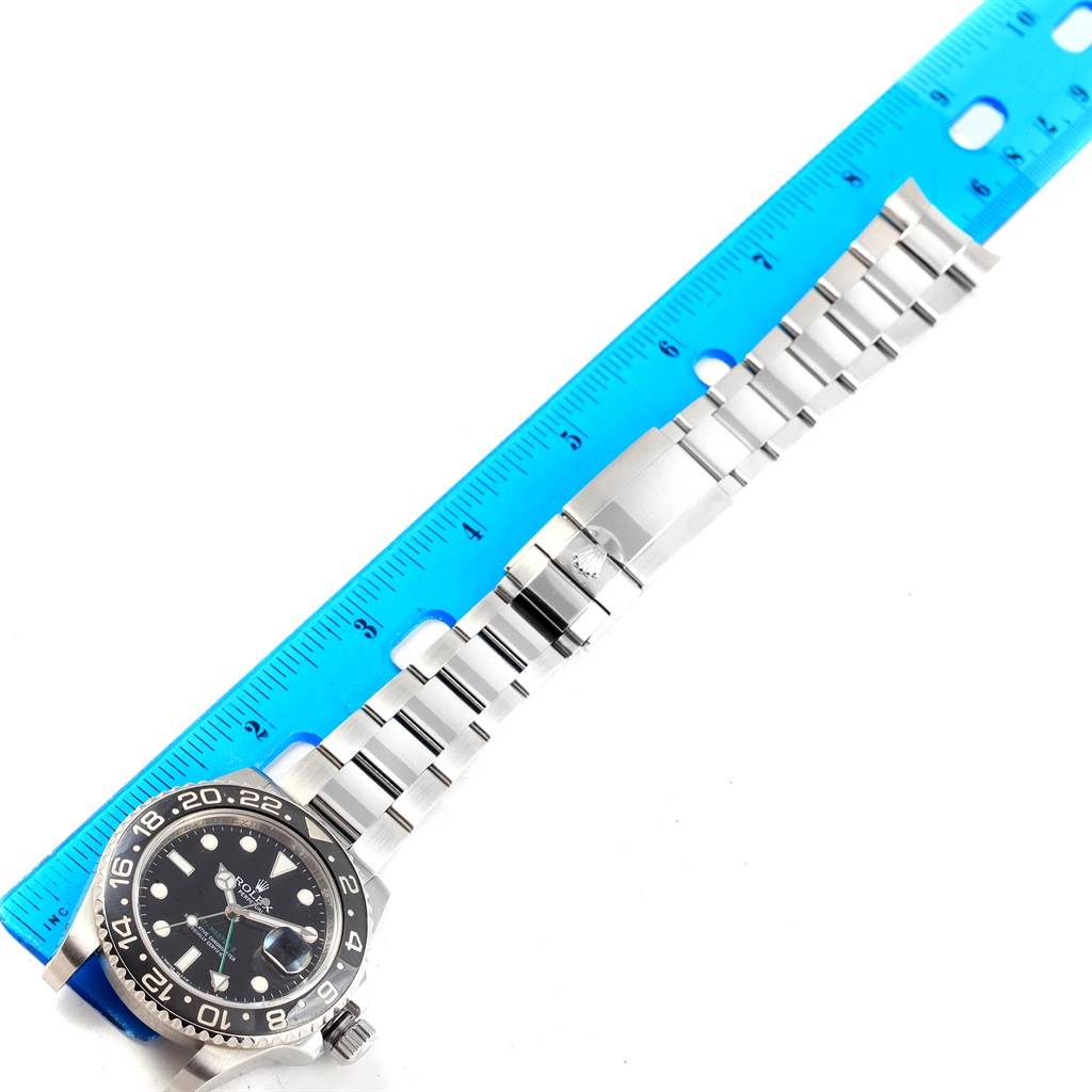 The Rolex GMT-Master 116710 Men's Stainless Steel Black Dial 116710 Men's Stainless Steel Black Dial watch is shown from a top view, displaying the face, bracelet, and clasp against a measuring ruler.