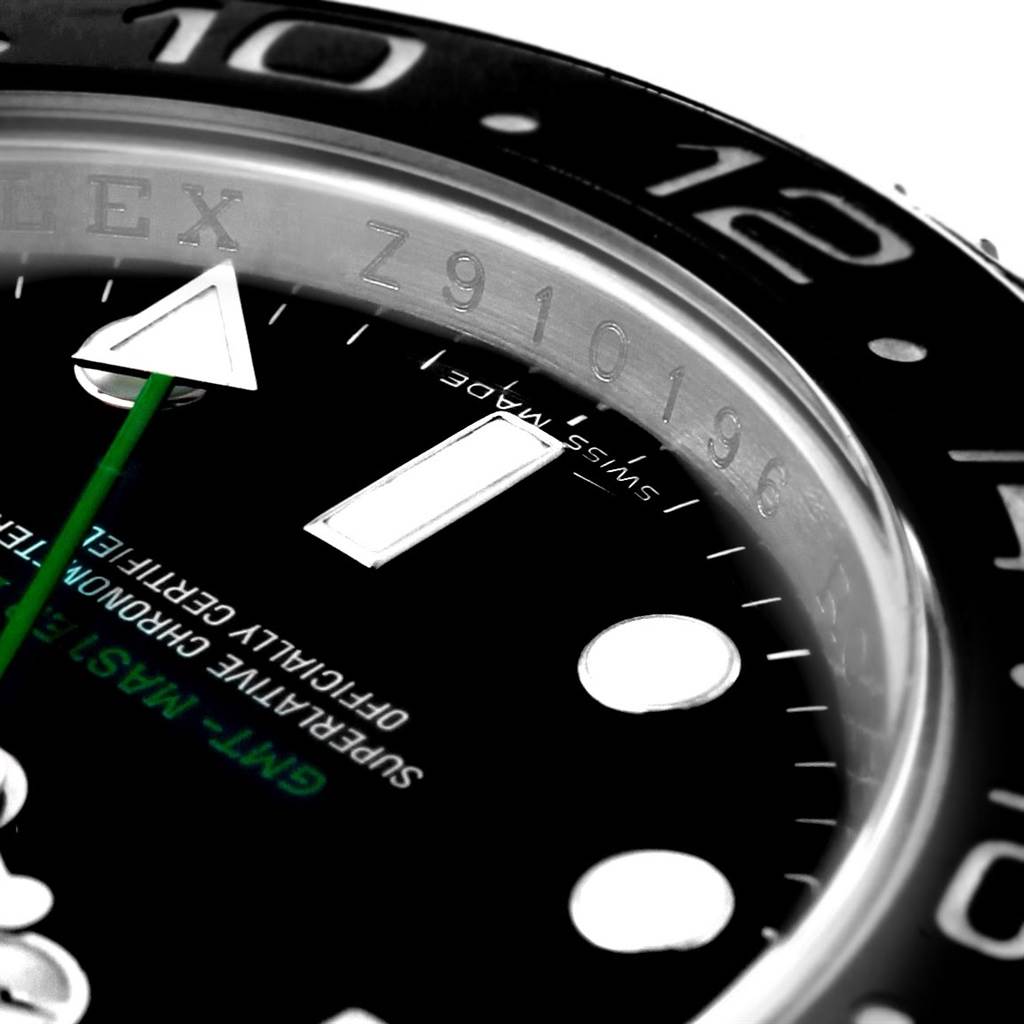 The image shows a close-up of the Rolex GMT-Master 116710 Men's Stainless Steel Black Dial 116710 Men's Stainless Steel Black Dial model, focusing on the bezel, hour markers, and part of the green hand.