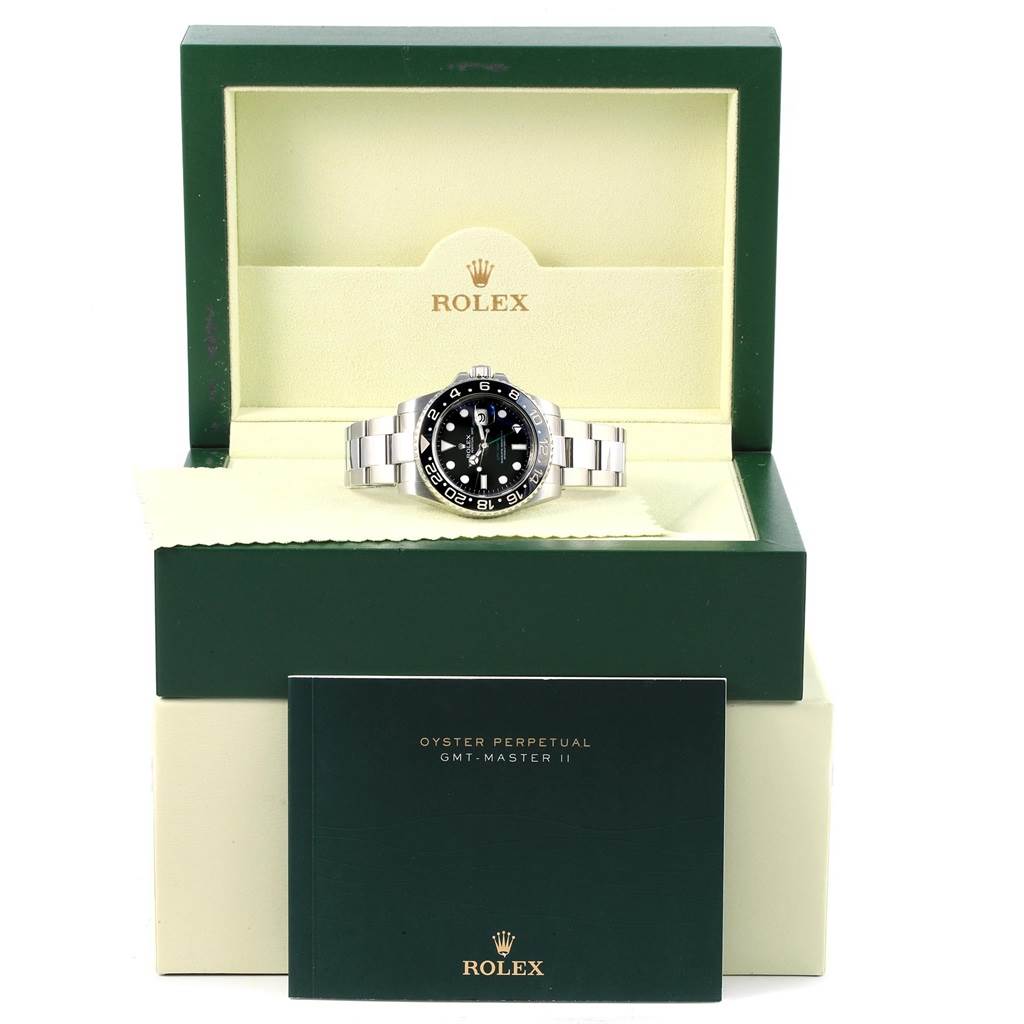 The Rolex GMT-Master 116710 Men's Stainless Steel Black Dial 116710 Men's Stainless Steel Black Dial watch is shown from the front, placed inside its open box with a booklet in front.