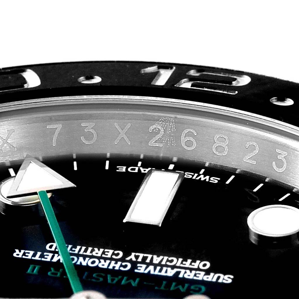 Close-up of a Rolex GMT-Master 116710 Men's Stainless Steel Black Dial 116710 Men's Stainless Steel Black Dial watch showing part of the bezel, hour markers, text, and central minute and GMT hands.