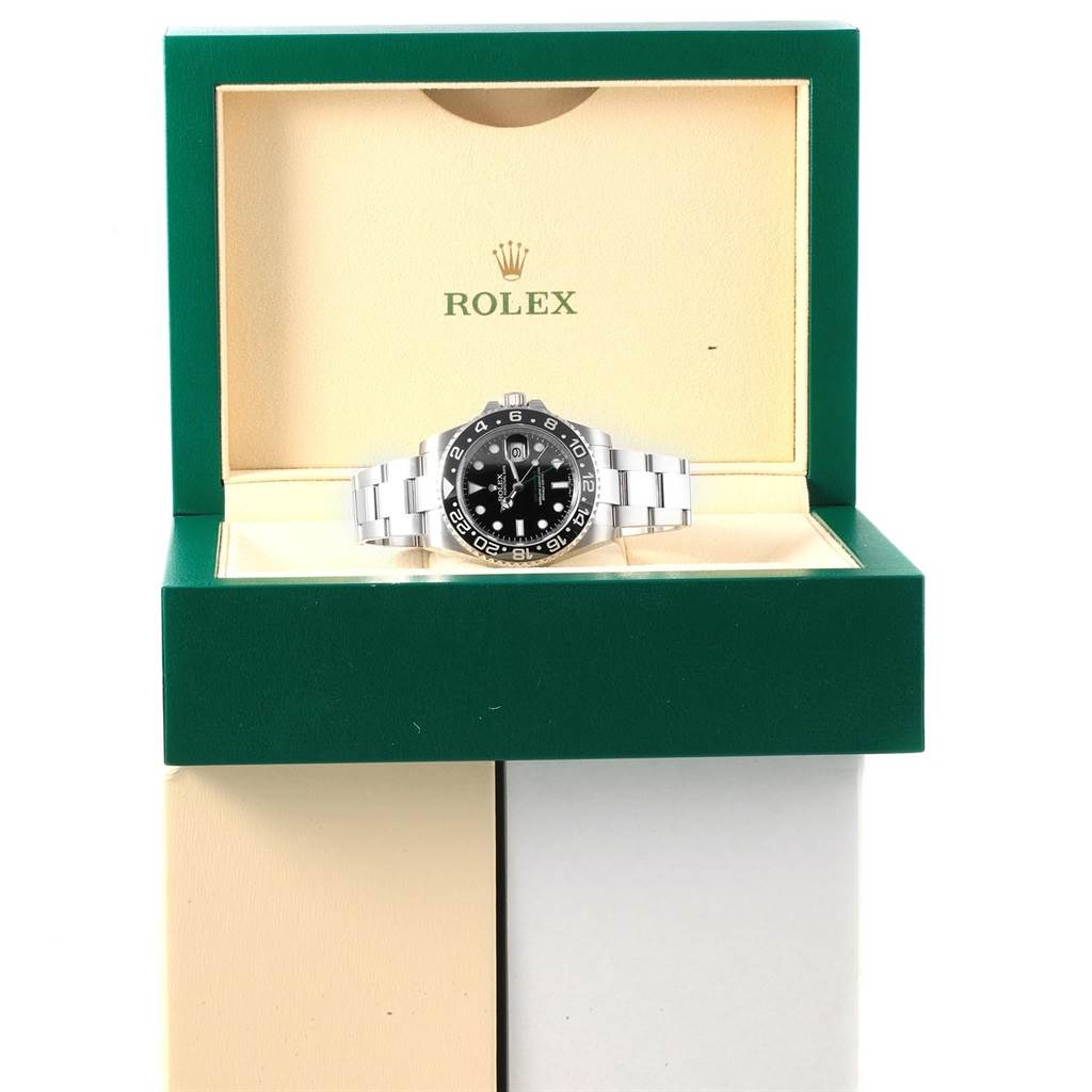 The Rolex GMT-Master 116710 Men's Stainless Steel Black Dial 116710 Men's Stainless Steel Black Dial watch is displayed front-facing in an open green and cream box.