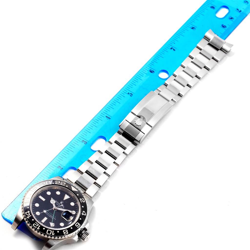 The image shows a Rolex GMT-Master 116710 Men
s Stainless Steel Black Dial 116710 Men
s Stainless Steel Black Dial watch laid flat with its stainless steel bracelet extended and aligned with a ruler.