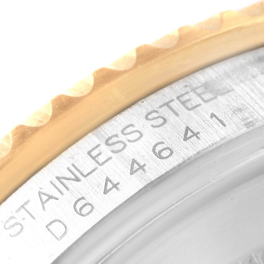 This close-up image of the Rolex GMT-Master 16713 Men's Stainless Steel Black Dial 16713 Men's Stainless Steel Black Dial watch shows part of the engraved bezel and the serial number on the stainless steel case.