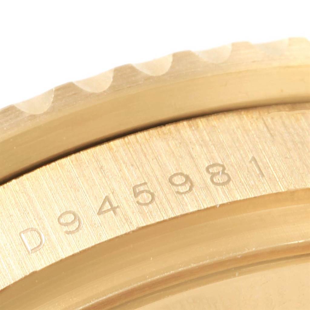 This close-up shows the outer edge and part of the case with the serial number of a Rolex GMT-Master 116718 Men's Yellow Gold Green Dial 116718 Men's Yellow Gold Green Dial watch.