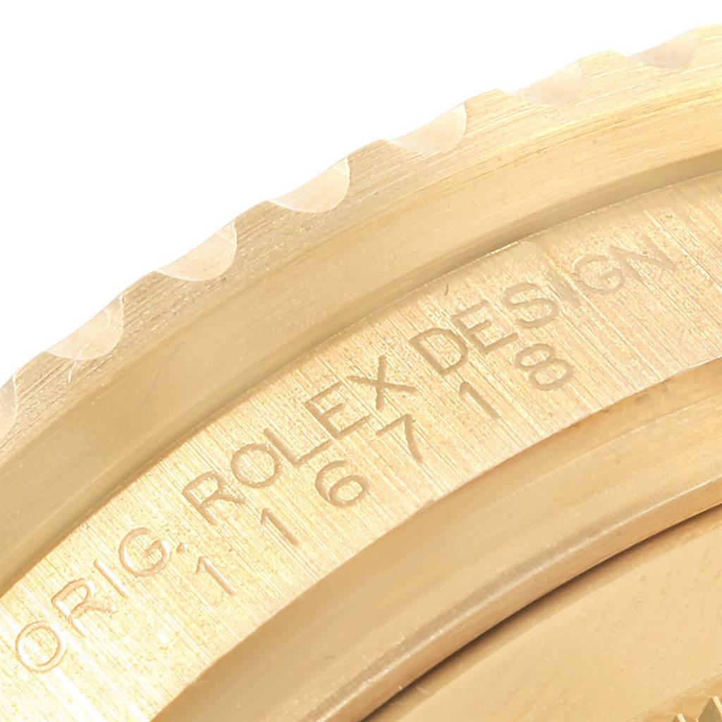 This close-up image shows the engraved details on the bezel of a Rolex GMT-Master 116718 Men's Yellow Gold Green Dial 116718 Men's Yellow Gold Green Dial watch.