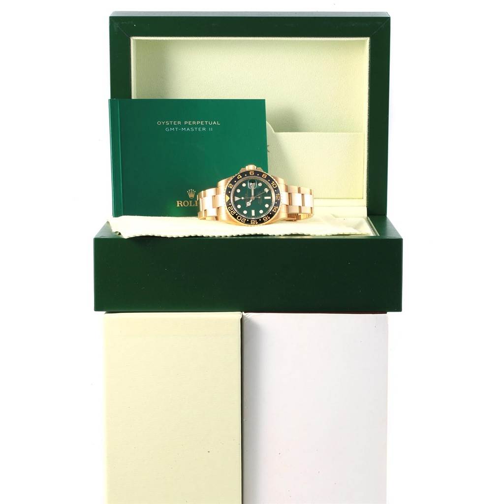The image shows a Rolex GMT-Master 116718 Men's Yellow Gold Green Dial 116718 Men's Yellow Gold Green Dial II watch placed inside an open green box with accompanying paperwork.
