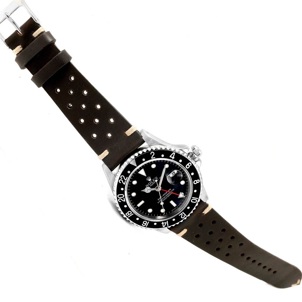 The Rolex GMT-Master 16700 Men's Stainless Steel Black Dial 16700 Men's Stainless Steel Black Dial watch is shown from an overhead angle, featuring its bezel, dial, and leather strap.