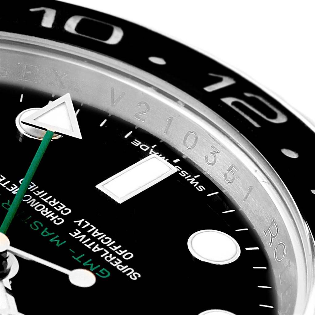 This close-up image of a Rolex GMT-Master 116710 Men's Stainless Steel Black Dial 116710 Men's Stainless Steel Black Dial watch shows a portion of the dial, hands, and part of the bezel with hour markings.