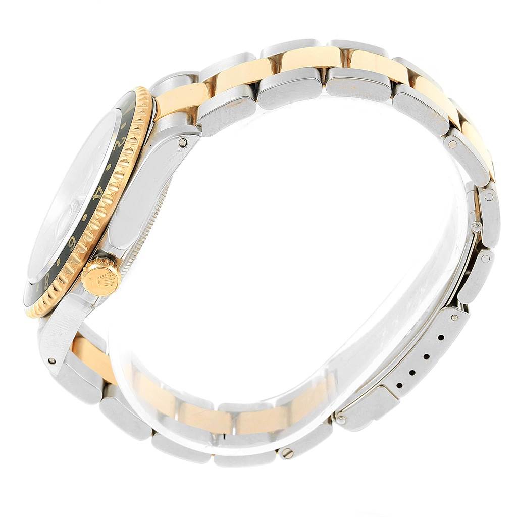 A side profile of the Rolex GMT-Master 16713 Men's Stainless Steel Champagne Dial 16713 Men's Stainless Steel Champagne Dial watch showcasing its bezel, crown, and two-tone bracelet.