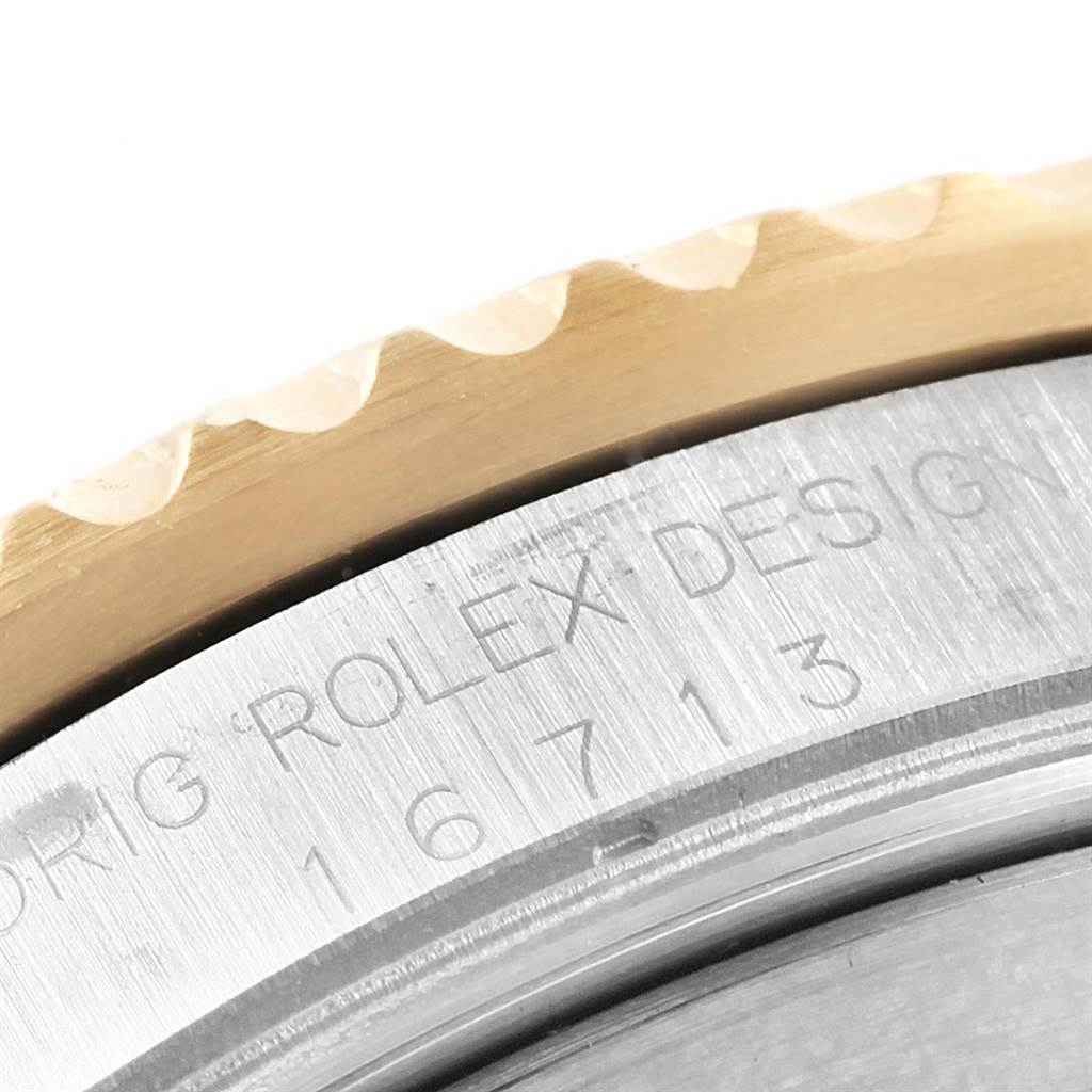 This close-up angle of the Rolex GMT-Master 16713 Men's Stainless Steel Champagne Dial 16713 Men's Stainless Steel Champagne Dial watch shows parts of its bezel and engravings on the case.