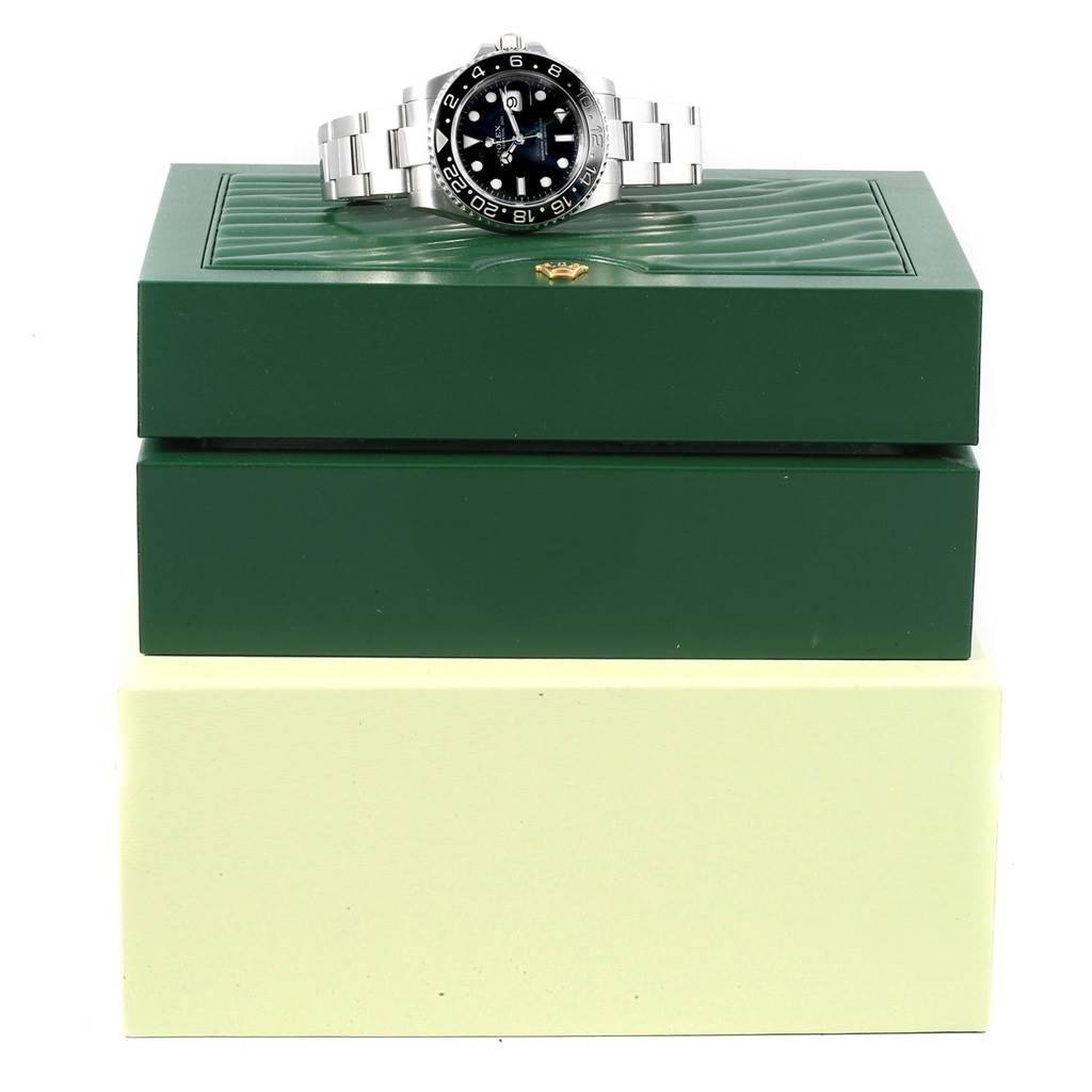 The image shows a Rolex GMT-Master 116710 Men's Stainless Steel Black Dial 116710 Men's Stainless Steel Black Dial watch placed on top of a green watch box, viewed from the front.