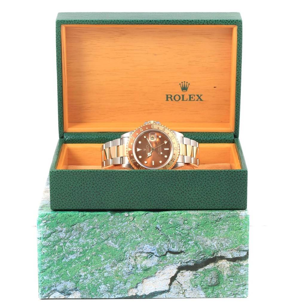 The photo shows a GMT-Master Rolex watch in a green and wooden Rolex box, taken from the front.