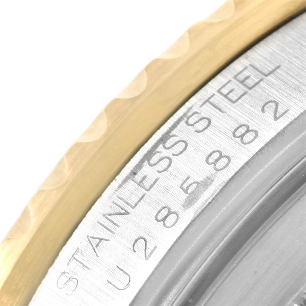 This is a close-up of the side engraving on the bezel of a Rolex GMT-Master 16713 Men's Stainless Steel Brown Dial 16713 Men's Stainless Steel Brown Dial, showing "STAINLESS STEEL" and a partial serial number.