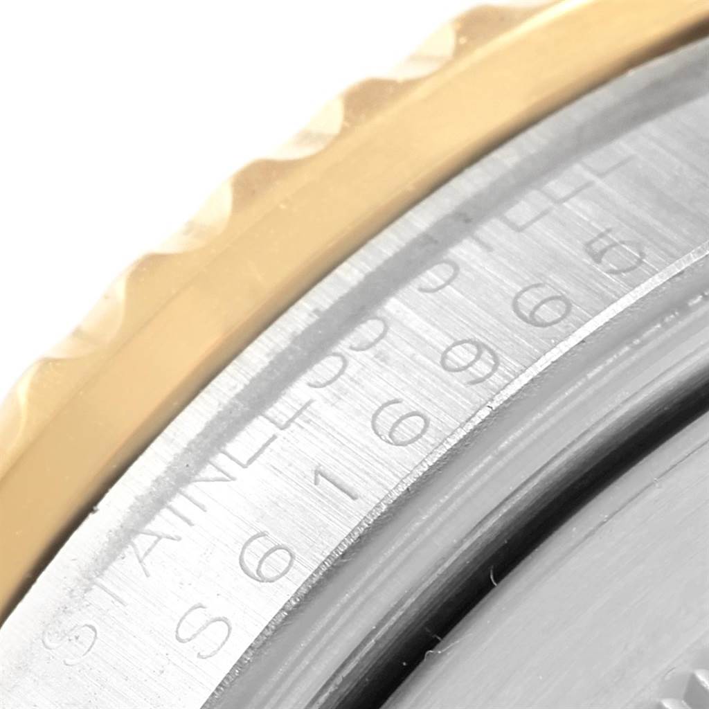 This close-up image shows the bezel and engraved serial number on the case of the Rolex GMT-Master 16713 Men's Steel and Gold (two tone) Champagne Dial 16713 Men's Steel and Gold (two tone) Champagne Dial watch.