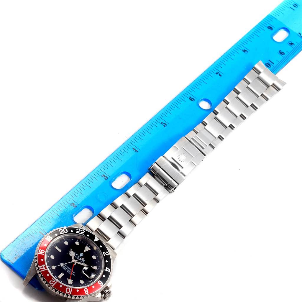 The image shows a top-down view of the Rolex GMT-Master 16710 Men's Stainless Steel Black Dial 16710 Men's Stainless Steel Black Dial watch, displaying the face, bezel, and stainless steel bracelet with a ruler for scale.