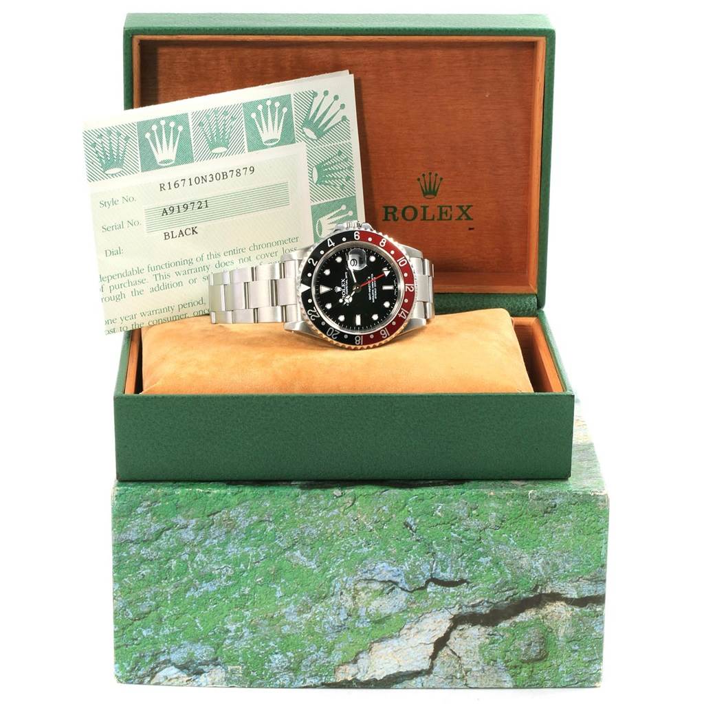 This image shows a Rolex GMT-Master 16710 Men's Stainless Steel Black Dial 16710 Men's Stainless Steel Black Dial watch displayed at an angle in its original box, accompanied by paperwork.
