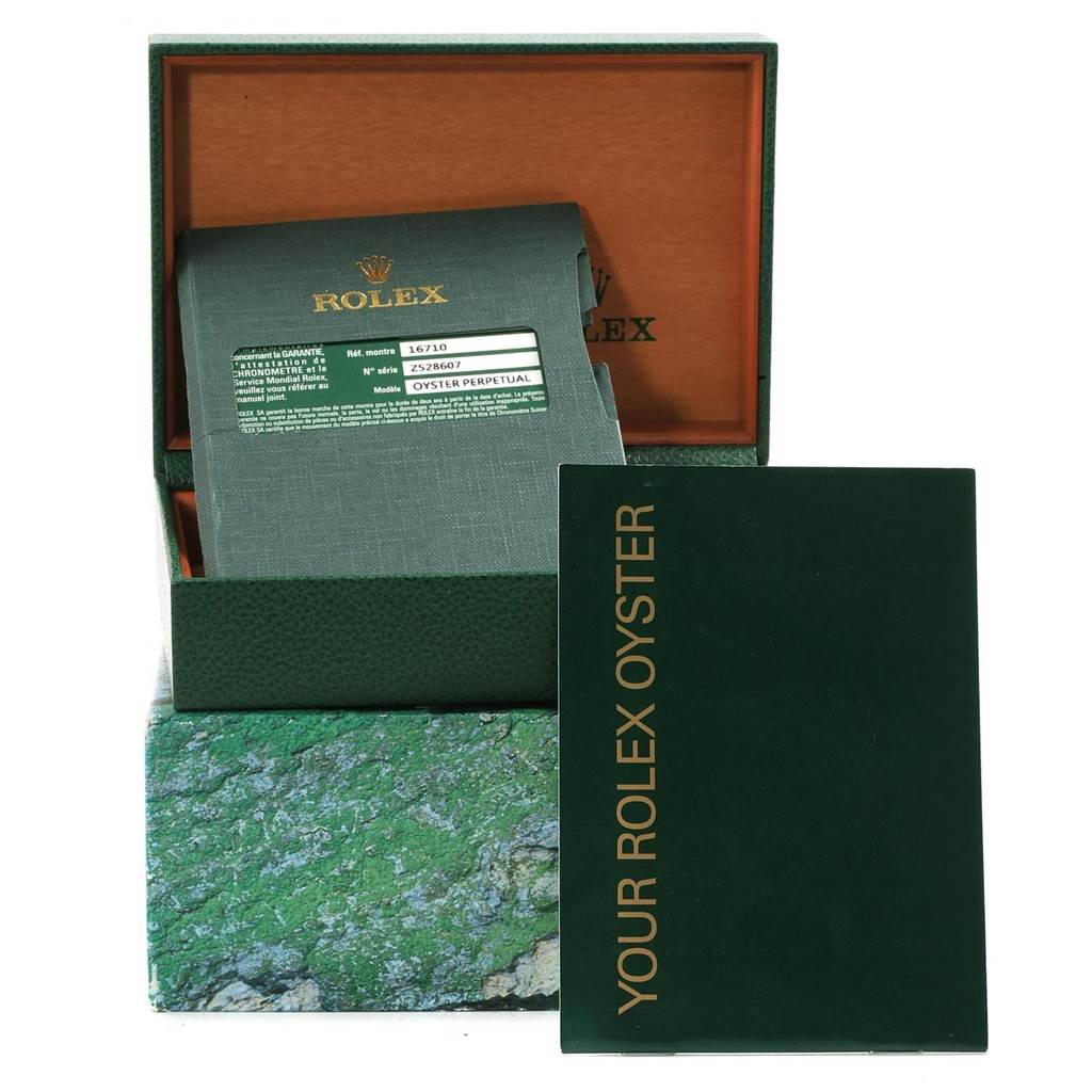 The image shows the packaging and warranty booklet for a Rolex GMT-Master 16710 Men's Stainless Steel Black Dial 16710 Men's Stainless Steel Black Dial watch, including the box and documentation.