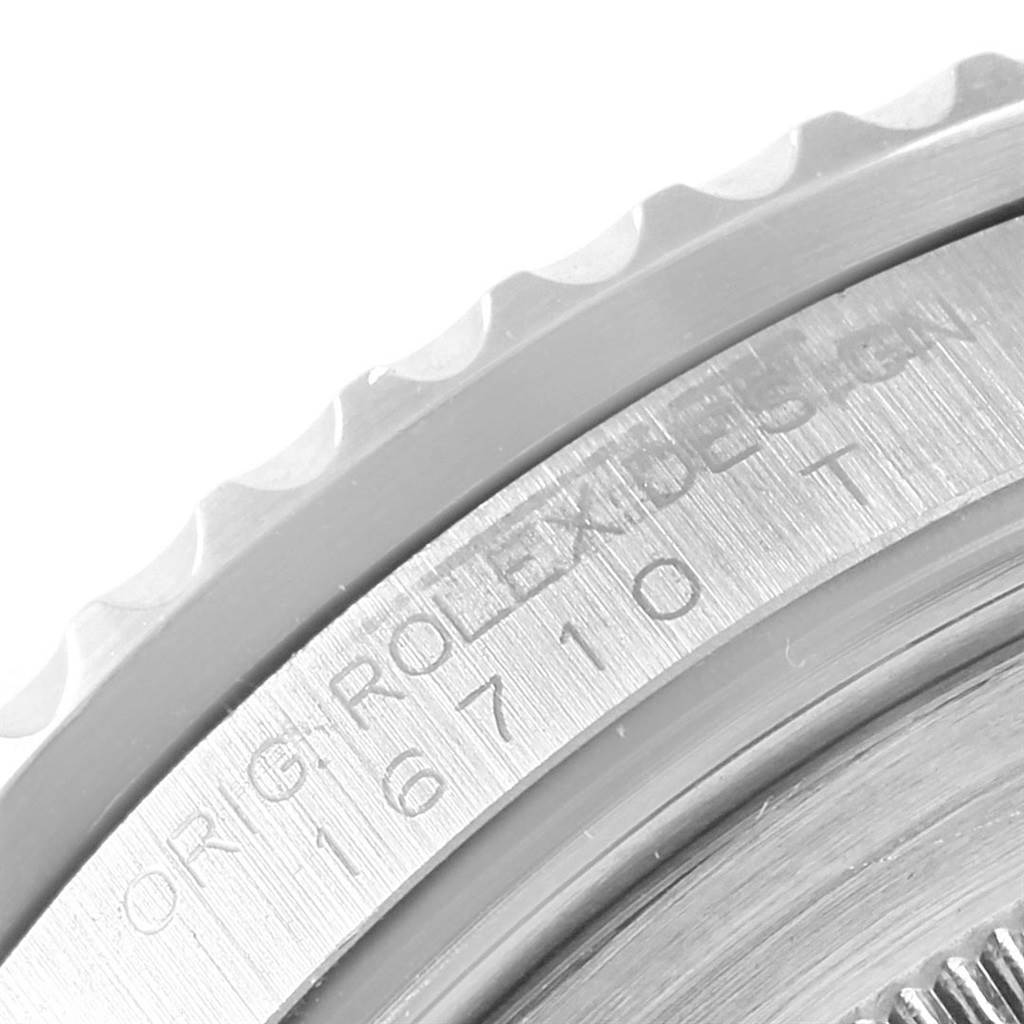 This image shows a close-up of the casing and bezel edge of a Rolex GMT-Master 16710 Men's Stainless Steel Black Dial 16710 Men's Stainless Steel Black Dial model, revealing part of its serial number and "ORIG. ROLEX DESIGN" engraving.
