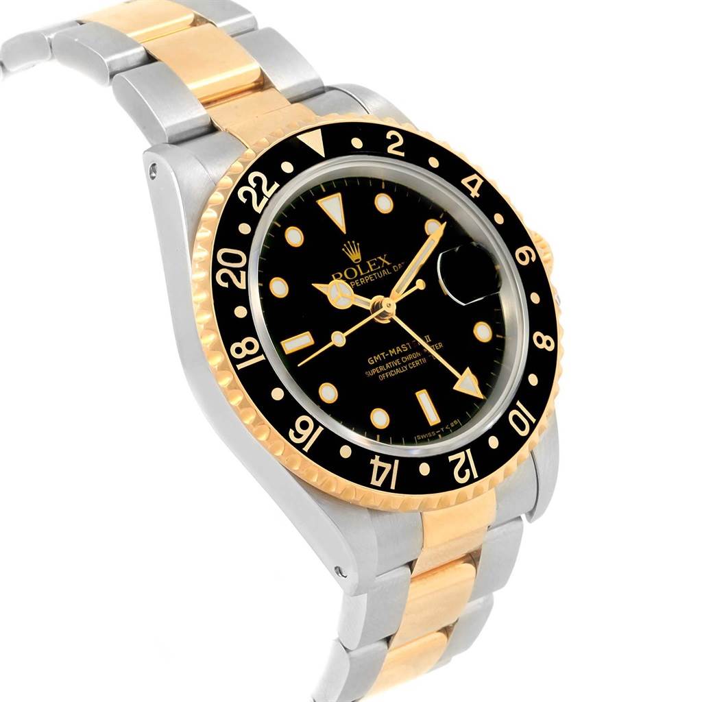 This Rolex GMT-Master 16713 Men's Stainless Steel Black Dial 16713 Men's Stainless Steel Black Dial watch is shown at a slight angle, displaying its black dial, black and gold bezel, and two-tone bracelet.