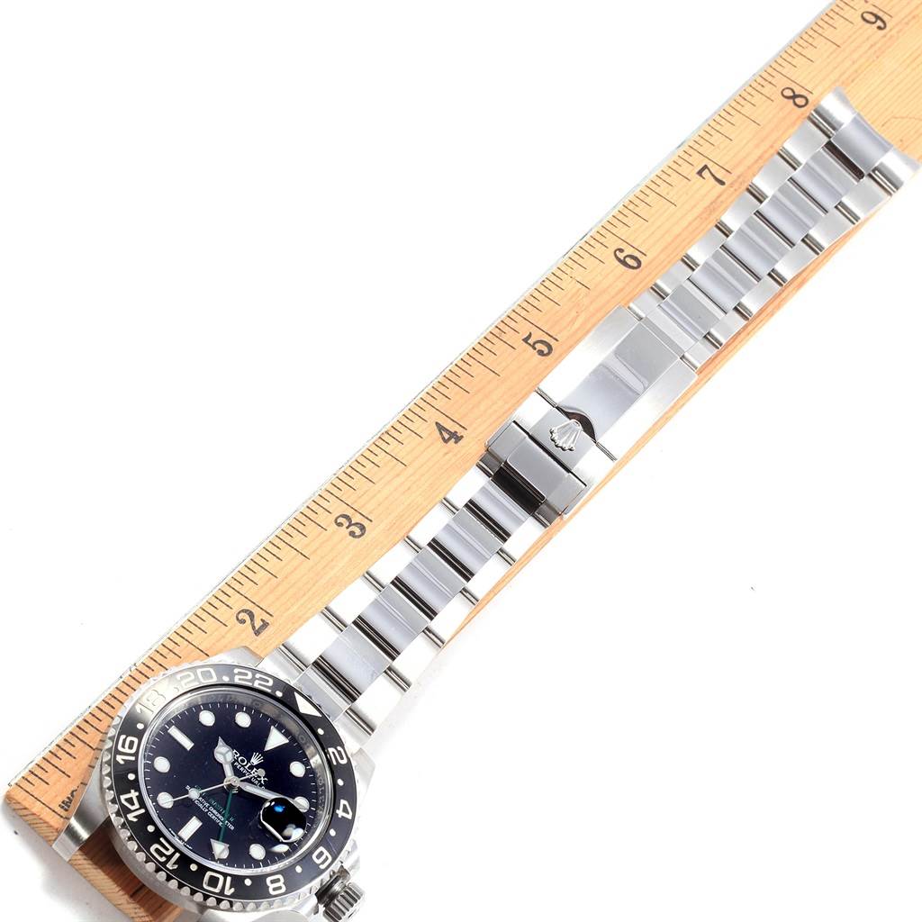 The image shows a Rolex GMT-Master 116710 Men's Stainless Steel Black Dial 116710 Men's Stainless Steel Black Dial watch laid next to a ruler, highlighting its stainless steel bracelet and clasp.