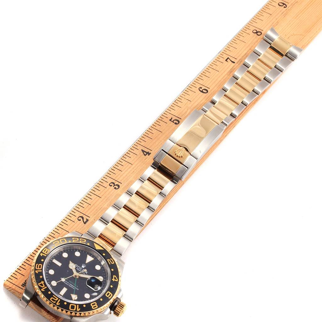 The image shows a Rolex GMT-Master 116713 Men's Stainless Steel Black Dial 116713 Men's Stainless Steel Black Dial watch laid flat alongside a ruler, highlighting its bracelet and case.