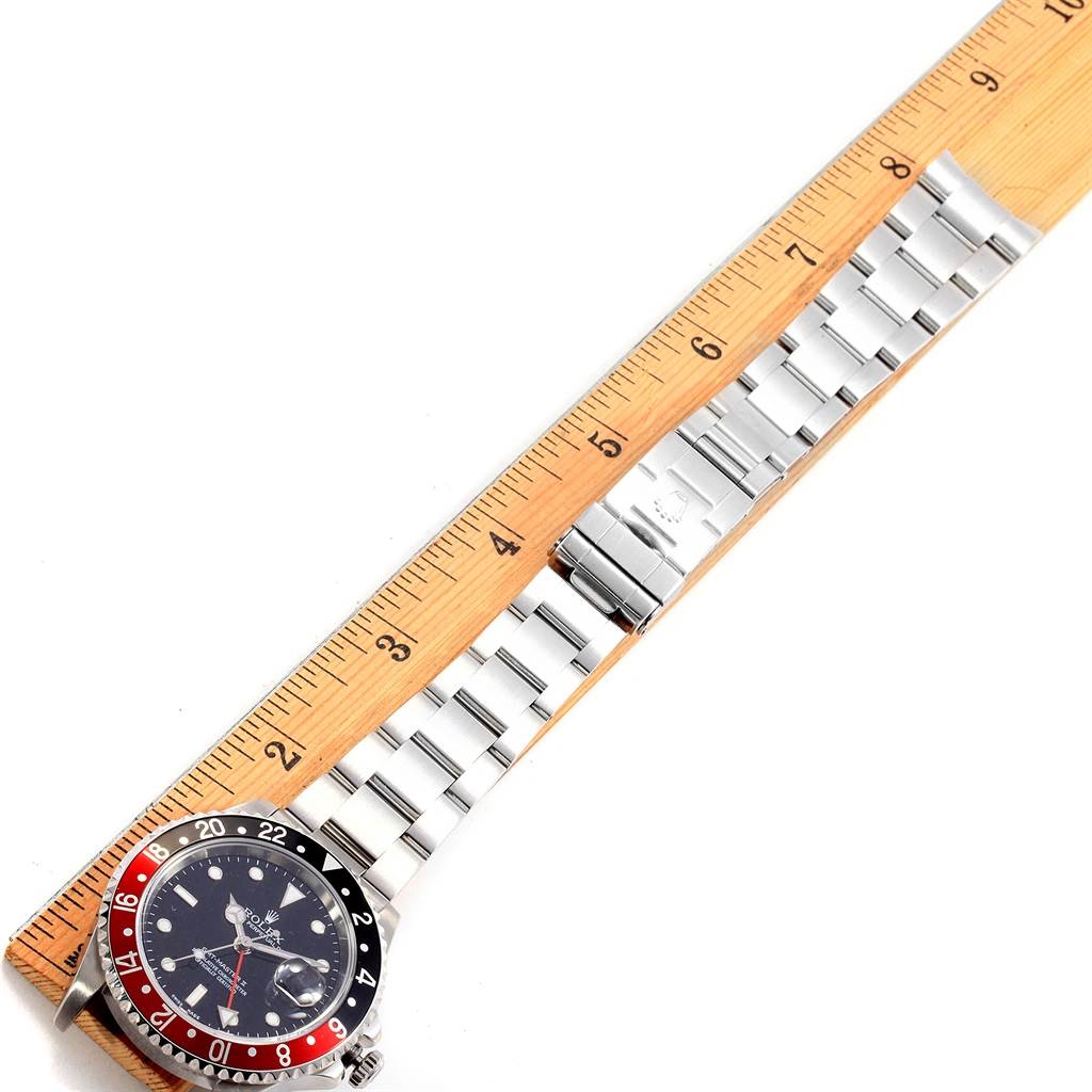 The image shows a top view of a Rolex GMT-Master 16710 Men's Stainless Steel Black Dial 16710 Men's Stainless Steel Black Dial watch with its entire bracelet laid next to a ruler for measurement.