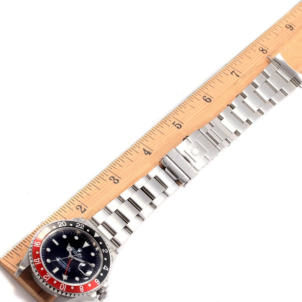 The image shows a top-view angle of a Rolex GMT-Master 16710 Men's Stainless Steel Black Dial 16710 Men's Stainless Steel Black Dial watch, showcasing the bracelet, bezel, dial, and partially open clasp against a ruler.