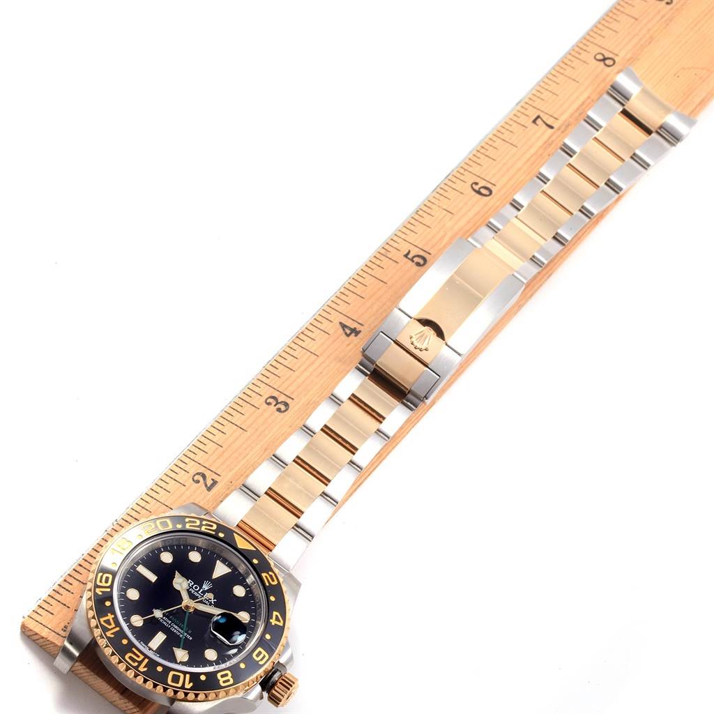 The image shows a Rolex GMT-Master 116713 Men's Stainless Steel Black Dial 116713 Men's Stainless Steel Black Dial watch with its band fully extended next to a ruler for measurement.