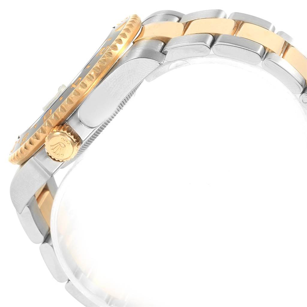 This side view of the Rolex GMT-Master 116713 Men's Stainless Steel Black Dial 116713 Men's Stainless Steel Black Dial shows the gold bezel, crown, and two-tone bracelet.