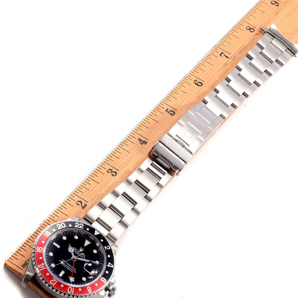 The image shows the face, bezel, and stainless steel bracelet of a Rolex GMT-Master 16710 Men's Stainless Steel Black Dial 16710 Men's Stainless Steel Black Dial watch, laid alongside a ruler for measurement.