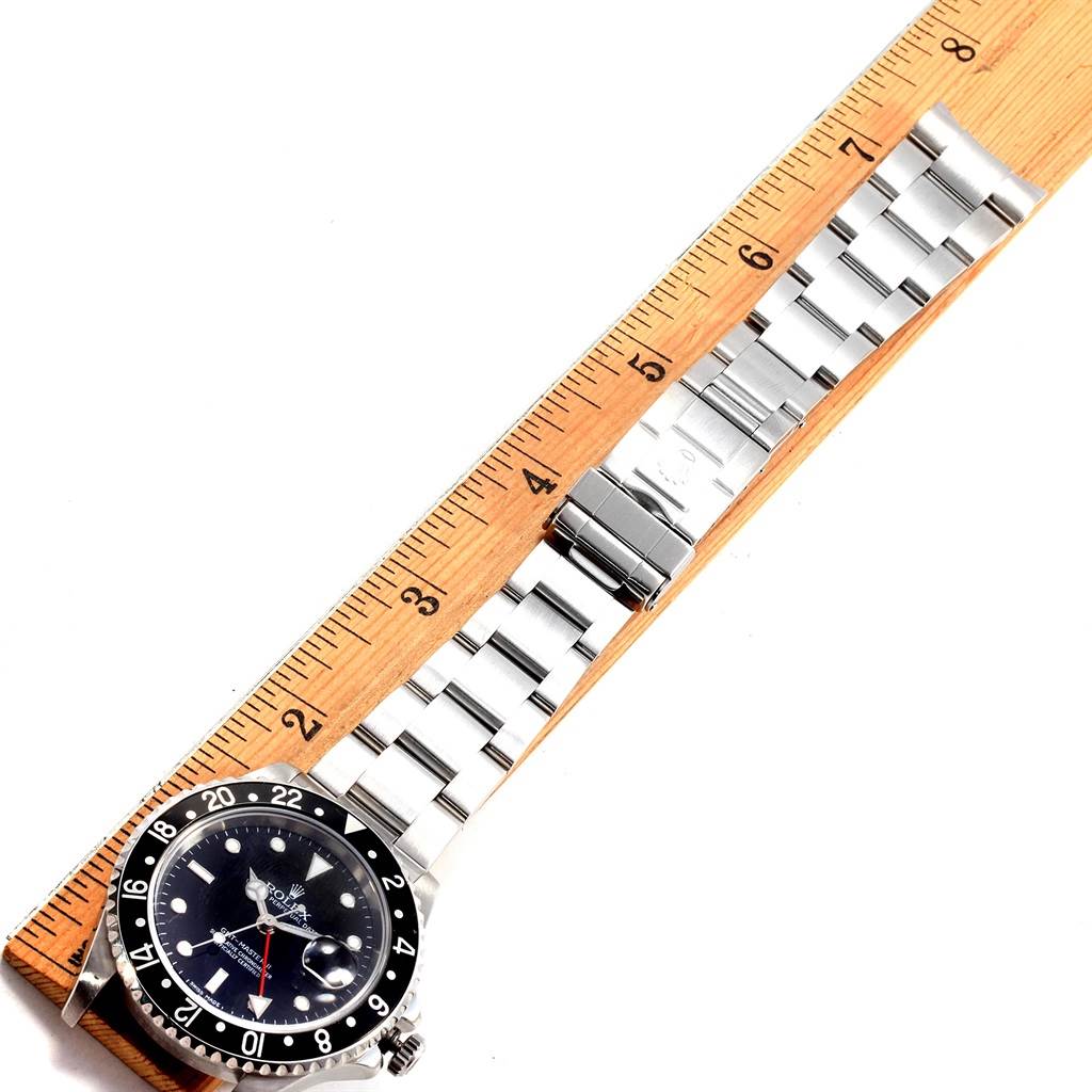 The image displays a Rolex GMT-Master 16710 Men's Stainless Steel Black Dial 16710 Men's Stainless Steel Black Dial watch laying flat, measured next to a ruler, showing the dial, bezel, and stainless steel bracelet.