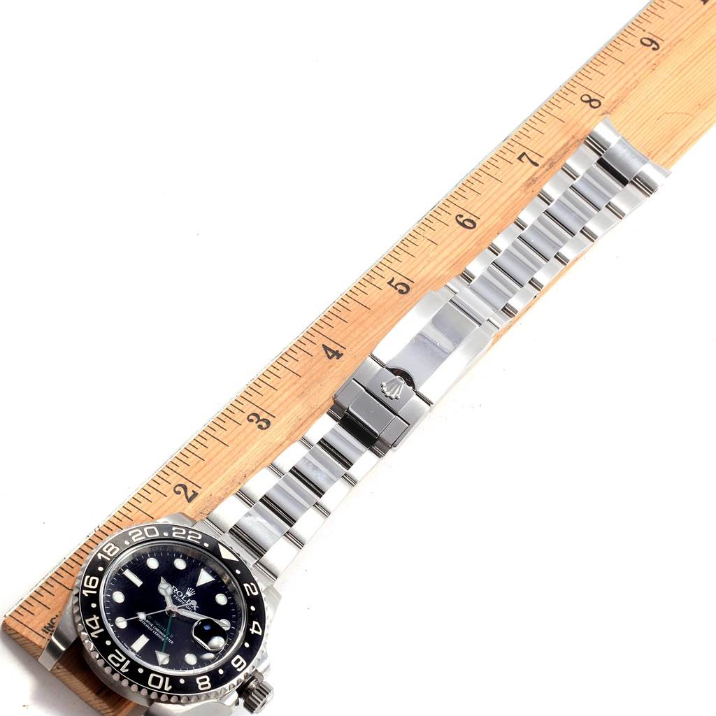 This image shows the Rolex GMT-Master 116710 Men's Stainless Steel Black Dial 116710 Men's Stainless Steel Black Dial watch from a top angle, including the face, bezel, and stainless steel bracelet beside a ruler.